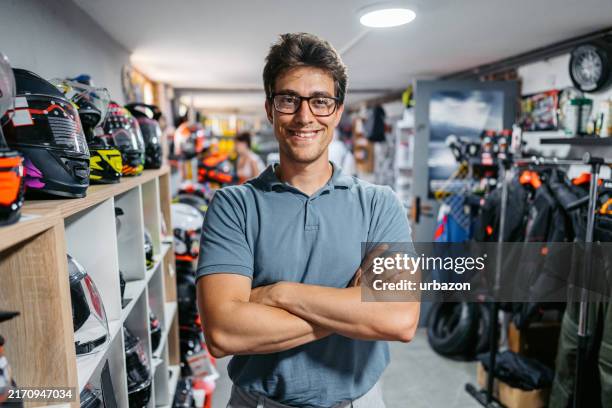 retail clerk standing in a moto shop - protective sportswear stock pictures, royalty-free photos & images