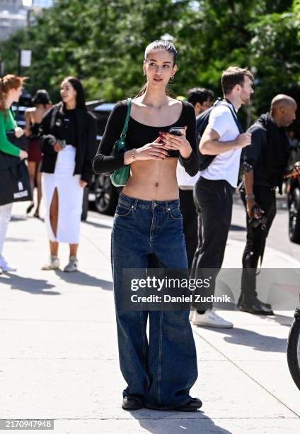 Model is seen wearing a black crop top and blue jeans with green bag outside the Off-White show during NYFW Spring/Summer 2025 on September 08, 2024...