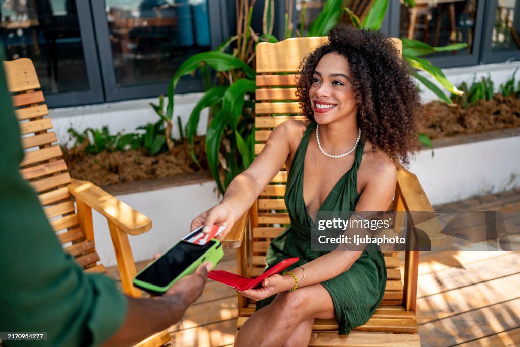 Smiling Woman Making a Contactless Payment Outdoors