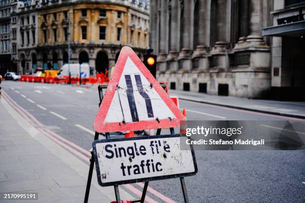 roadway reduction road sign, city centre - señal-de-obras-en-la-vía fotografías e imágenes de stock