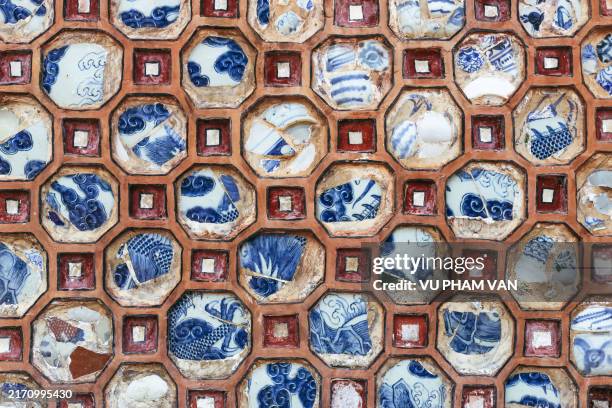decorated wall with porcelain pieces forming geometrical shape - traditional vietnam stock pictures, royalty-free photos & images