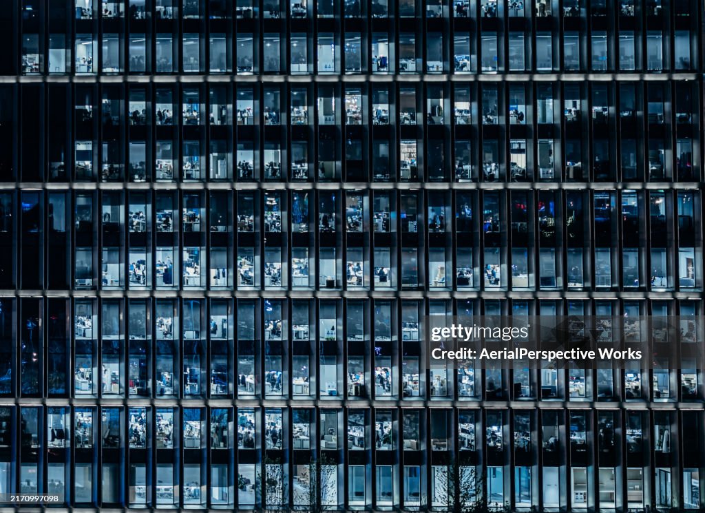 Luftaufnahme von überfüllten Geschäftsleuten, die nachts in einem Bürogebäude arbeiten