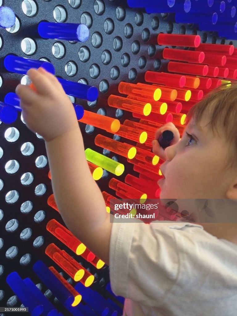 男の子は色付きのペグで遊ぶ