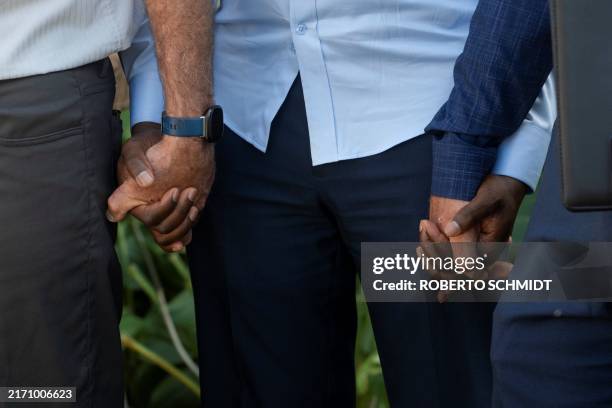 Vilés Dorsainvil , the Executive Director of the Haitian Community Help and Support Center, holds hands with US pastors during a prayer at the end of...