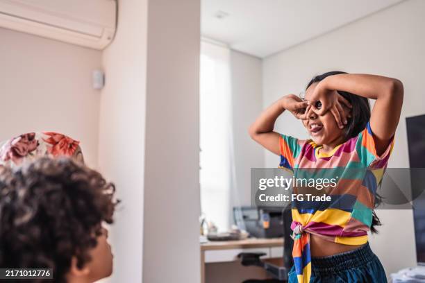 girl playing charades with family at home - pantomime stock pictures, royalty-free photos & images