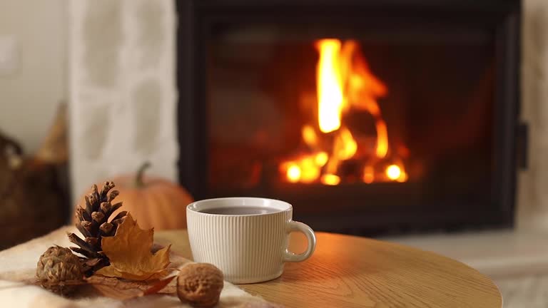 https://media.gettyimages.com/id/2171016095/video/autumn-hygge-cup-of-warm-tea-pumpkins-autumn-leaves-on-wooden-table-against-burning-fireplace.jpg?b=1&s=640x640&k=20&c=5ucNMOE9WhL7q0IRd5aiMyi6H2xAbghw5OXTGHWati4=