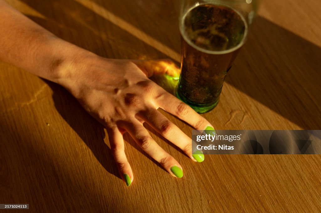 Top view of young woman hand with a beer