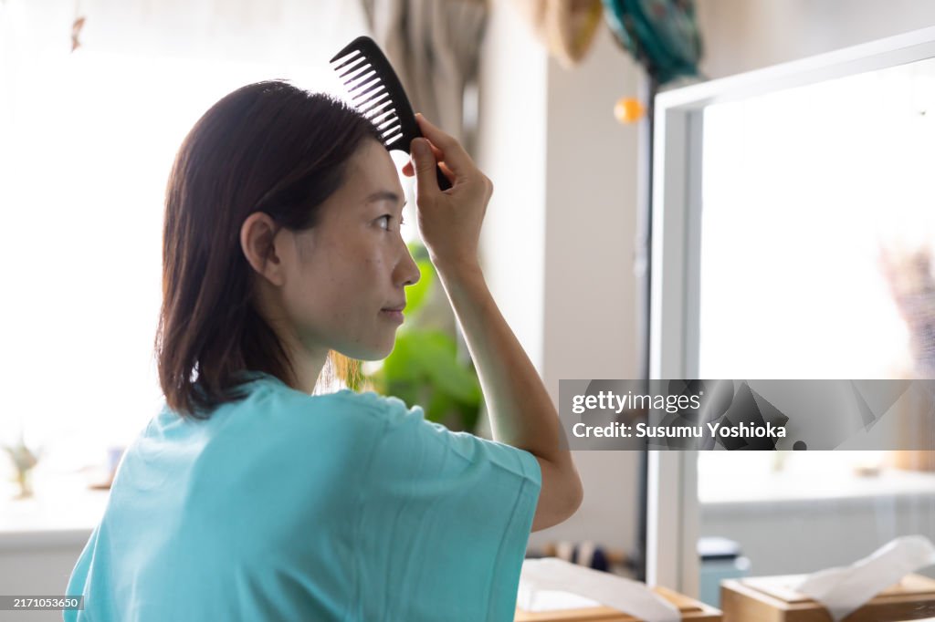 A woman taking care of her hair.
