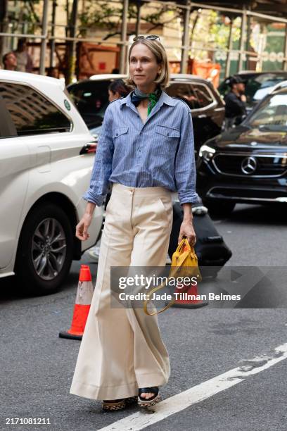 Guest is seen wearing a blue shirt, green bandana, khaki pant, black sandals and carrying a yellow bag outside the Carolina Herrera show during New...
