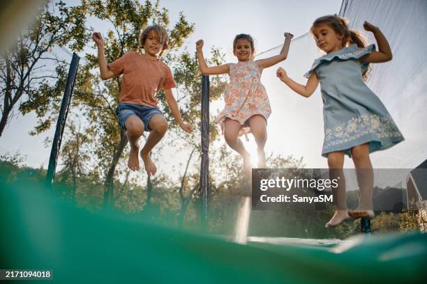 beautiful children enjoying summer - trampoline jumping stock pictures, royalty-free photos & images