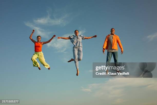 happy friends levitating in mid-air - levitation stock pictures, royalty-free photos & images