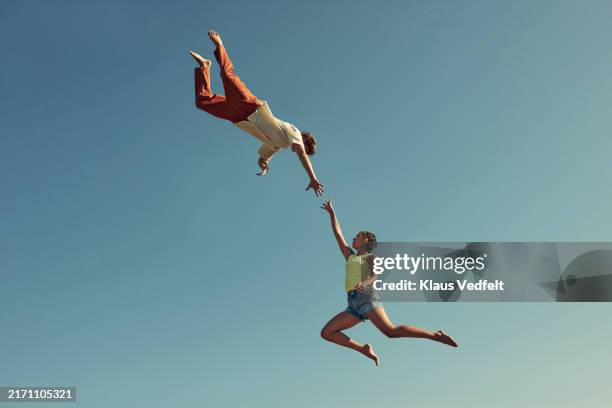 friends trying to hold hands in mid-air - oresund region stock pictures, royalty-free photos & images