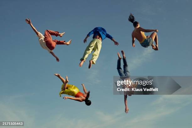 friends in casuals falling in mid-air - agility stock pictures, royalty-free photos & images