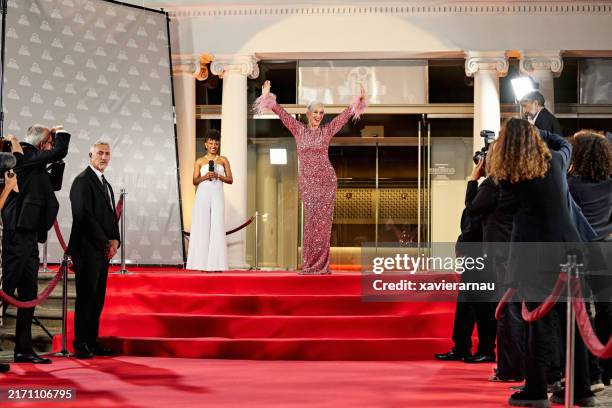 reife berühmtheit im paillettenkleid posiert für fotografen - paillettenkleid stock-fotos und bilder