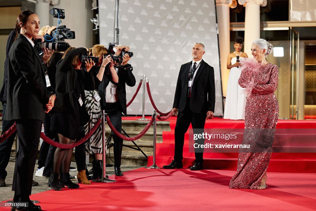 Cheerful celebrity posing for event photographers