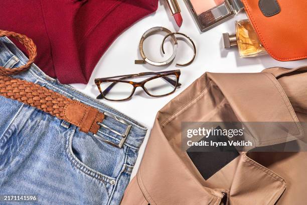set of fashion collection with trendy fashion clothes and accessories beige suede belt, horn rimmed sunglasses, jewellery, accessories and make-up cosmetic products for women in maroon red, beige, blue and brown colours. - colección de la moda fotografías e imágenes de stock