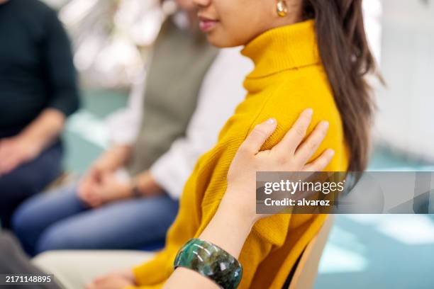 close-up of psychologist put her hand on shoulder of upset woman and supporting her - encouragement stock pictures, royalty-free photos & images