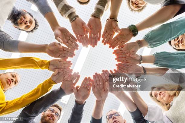 support group standing in a circle with hands together - hand stack stock pictures, royalty-free photos & images