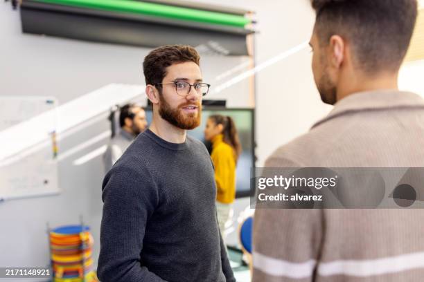 zwei männer, die während einer gruppentherapiesitzung miteinander sprechen - sich verschönern stock-fotos und bilder