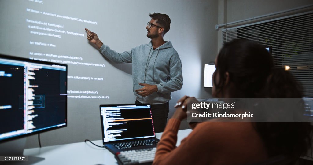 Hispanic Latin American software engineer developer use laptop computer program coding, projection screen presentation. Programming language development, business technology, night work people concept