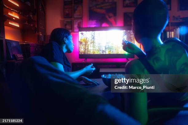 dos mujeres jóvenes que miran la película y comen palomitas de maíz - servicio a la carta fotografías e imágenes de stock