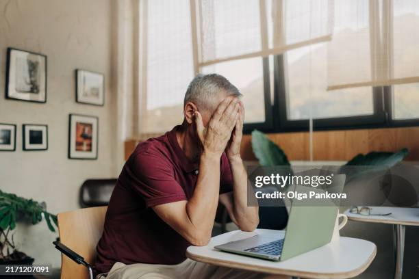 tired and upset mature man uses laptop - emotional stress stock pictures, royalty-free photos & images