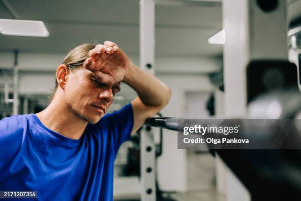 tired middle-aged man in the gym - fragilidad fotografías e imágenes de stock