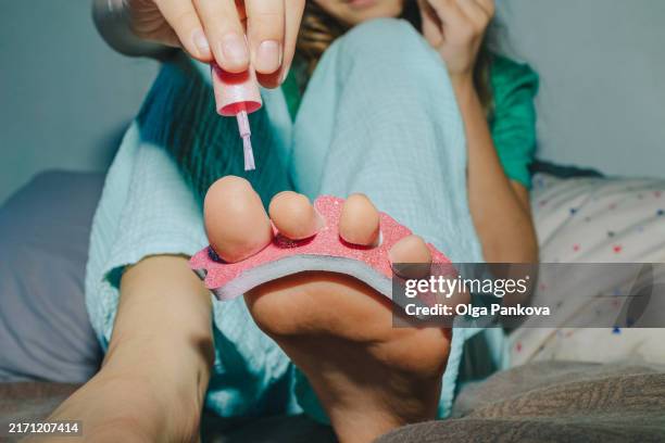 young pre-teen girl is giving herself a pedicure - pedicure stock pictures, royalty-free photos & images