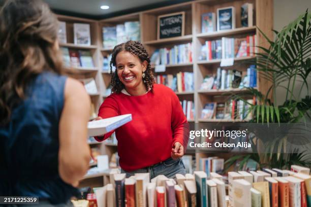 woman buying books at store - book shop stock pictures, royalty-free photos & images