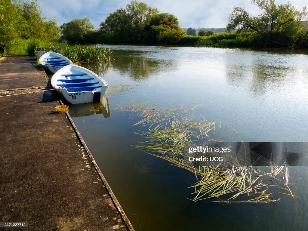 Two rowboats moored at Radley Boathouse by the Thames, summer morning