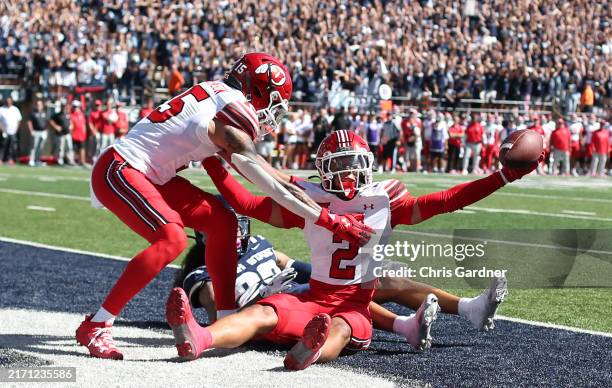 Smith Snowden of the Utah Utes celebrates an interception in the endzone with teammate Tao Johnson against Kyrese White of the Utah State Aggies...
