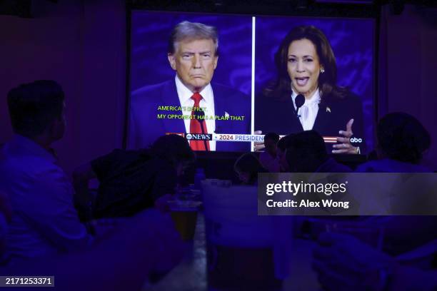 People watch the presidential debate during a debate watch party at Penn Social on September 10, 2024 in Washington, DC. Democratic presidential...