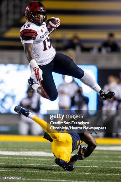 San Diego State running back Marquez Cooper leaps over California defensive back Lu-Magia Hearns III during the first half of their NCAA football...