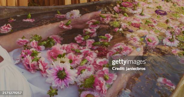 pregnant woman with towel on hair in bath. spa day and relaxation in water full of scented flowers to relax - petal stock pictures, royalty-free photos & images