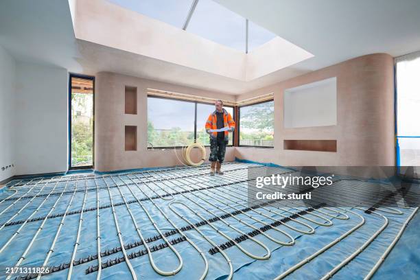 plumber installing underfloor heating pipes - underfloor heating stock pictures, royalty-free photos & images
