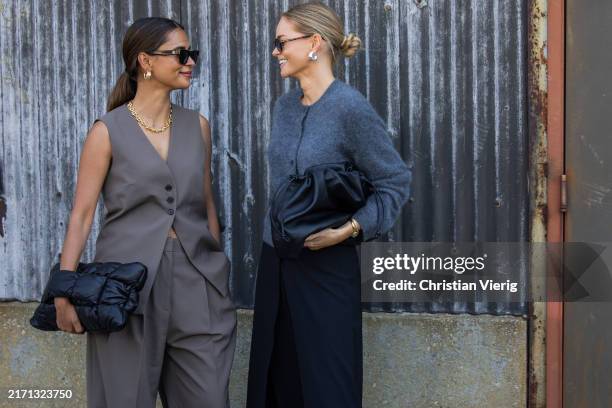 Emelie Lindmark wears grey vest, pants, black bag & Claire Rose Cliteur wears grey cardigan, black bag, pants outside Cos during New York Fashion...