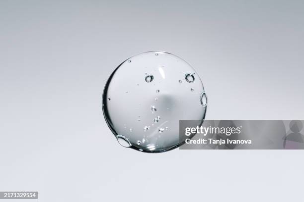 liquid drop of gel. serum transparent cosmetic sample texture with bubbles on gray background - aminoácido fotografías e imágenes de stock