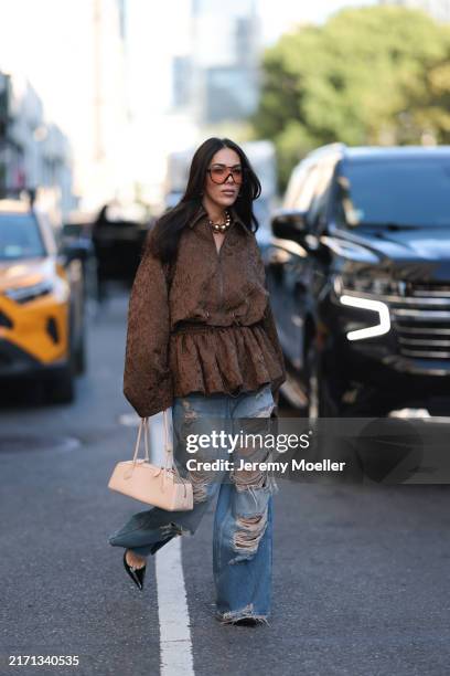 Olga Sokolenko seen wearing black sunglasses with orange sheer lenses, large gold pearl necklace, Rogov brown pattern embroidered oversized jacket,...