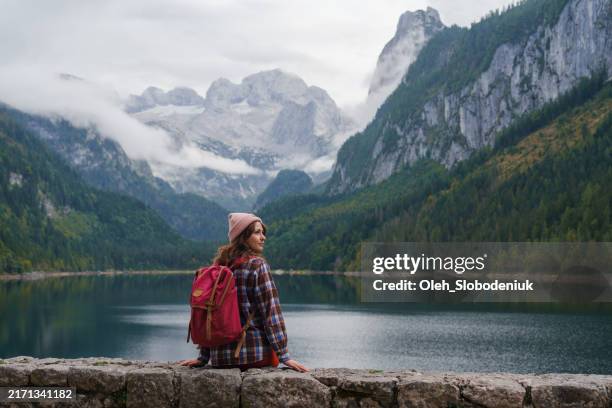 woman sitting on the background of gosausee lake in autumn - austrian culture stock pictures, royalty-free photos & images