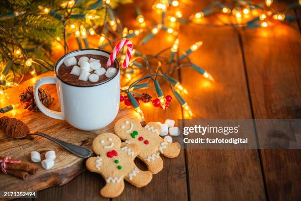 chocolate caliente con malvaviscos y galletas de jengibre en una acogedora mesa navideña - figurita de jengibre fotografías e imágenes de stock