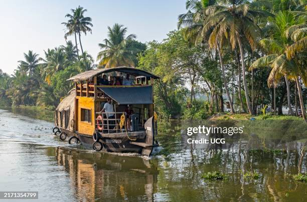 Traditional houseboat cruises along the channels near Kumarakom, offering a glimpse into the unique way of exploring the tranquil Kerala backwaters,...
