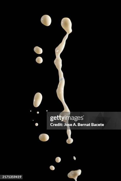 cow's milk jet in falling motion on a black background. - hovering stock pictures, royalty-free photos & images