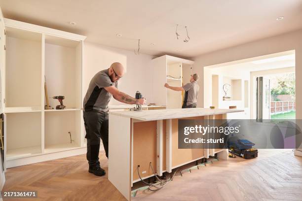 kücheneinbau-team bei der montage - stromkasten stock-fotos und bilder