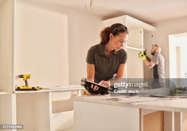 kitchen fitter checking online plans - installing new kitchen stock pictures, royalty-free photos & images
