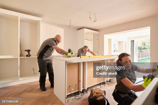 kitchen fitting team installing - kitchen renovation stock pictures, royalty-free photos & images