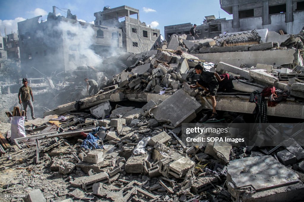 Palestinians inspect their destroyed homes after the Israeli...