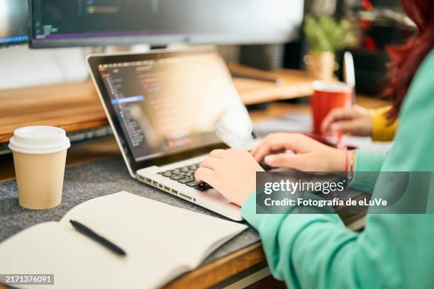 female computer programmer writing code on laptop in office - html stock pictures, royalty-free photos & images