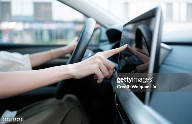 the car driver is operating the car center control screen - cuadro de instrumentos fotografías e imágenes de stock