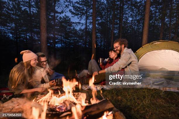 young happy couples enjoying on camping during evening in the woods. - open fire stock pictures, royalty-free photos & images