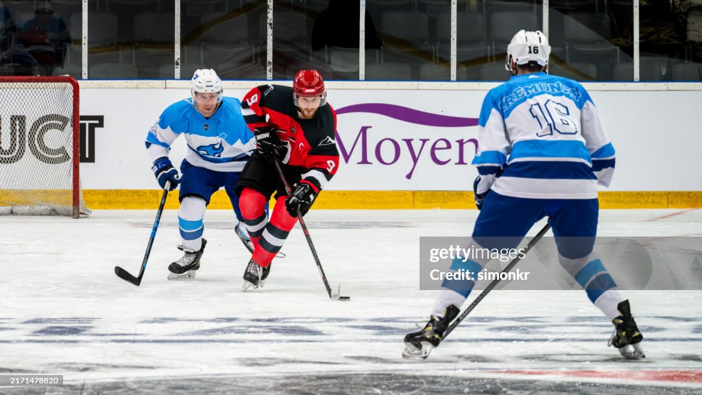 Ice Hockey Duel: Offensive Breakthrough, player dribbling against opposing defenders